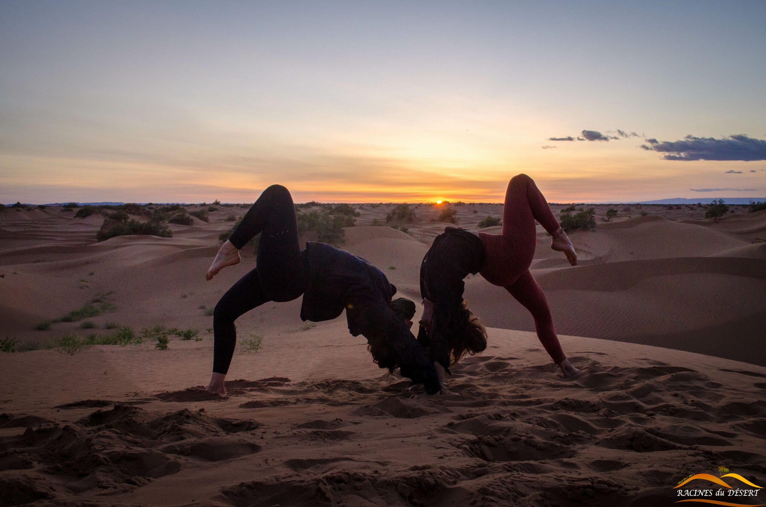 silhouettes femmes yoga coucher de soleil désert