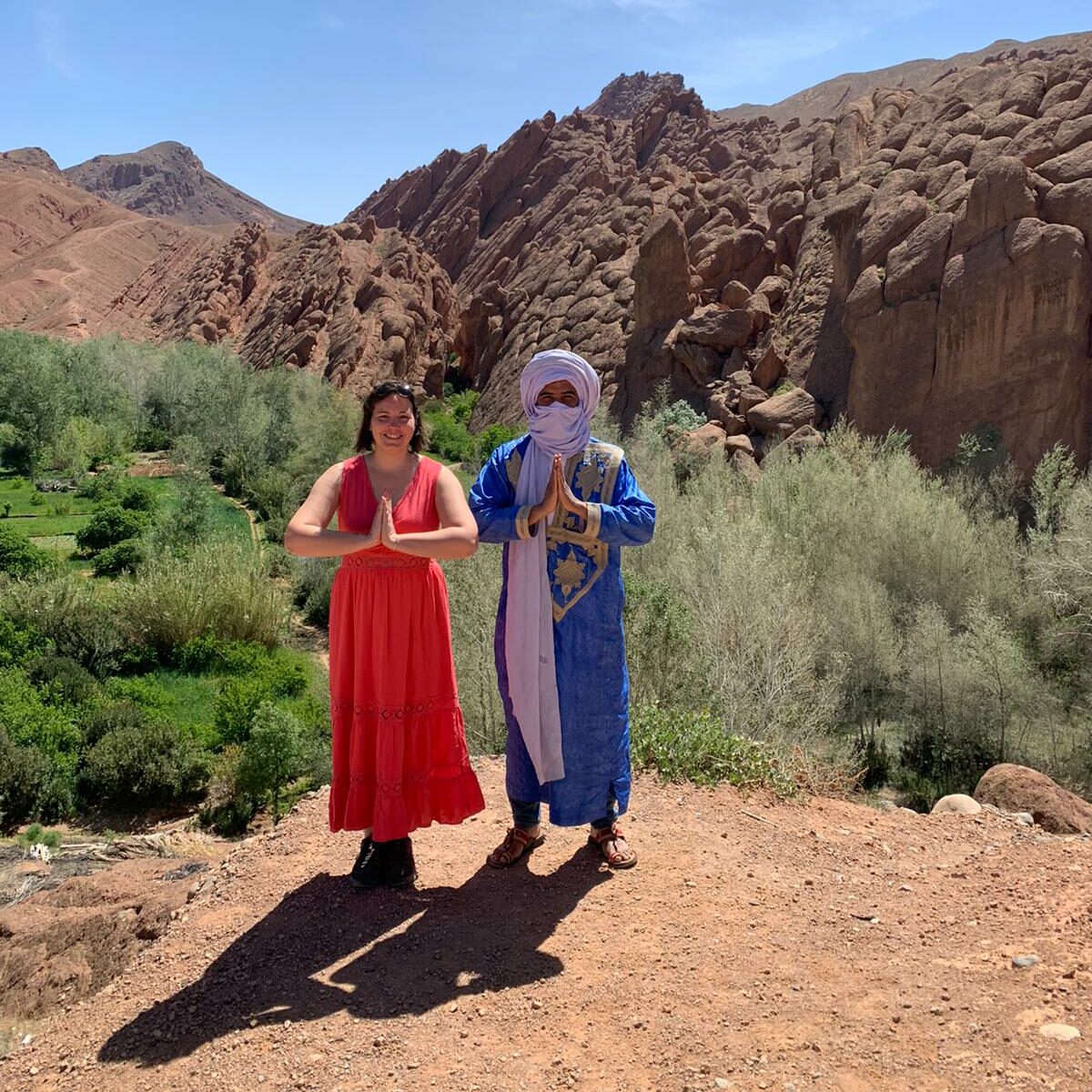 Un Nomade et une femme en rouge Namasté montagne de l'Atlas